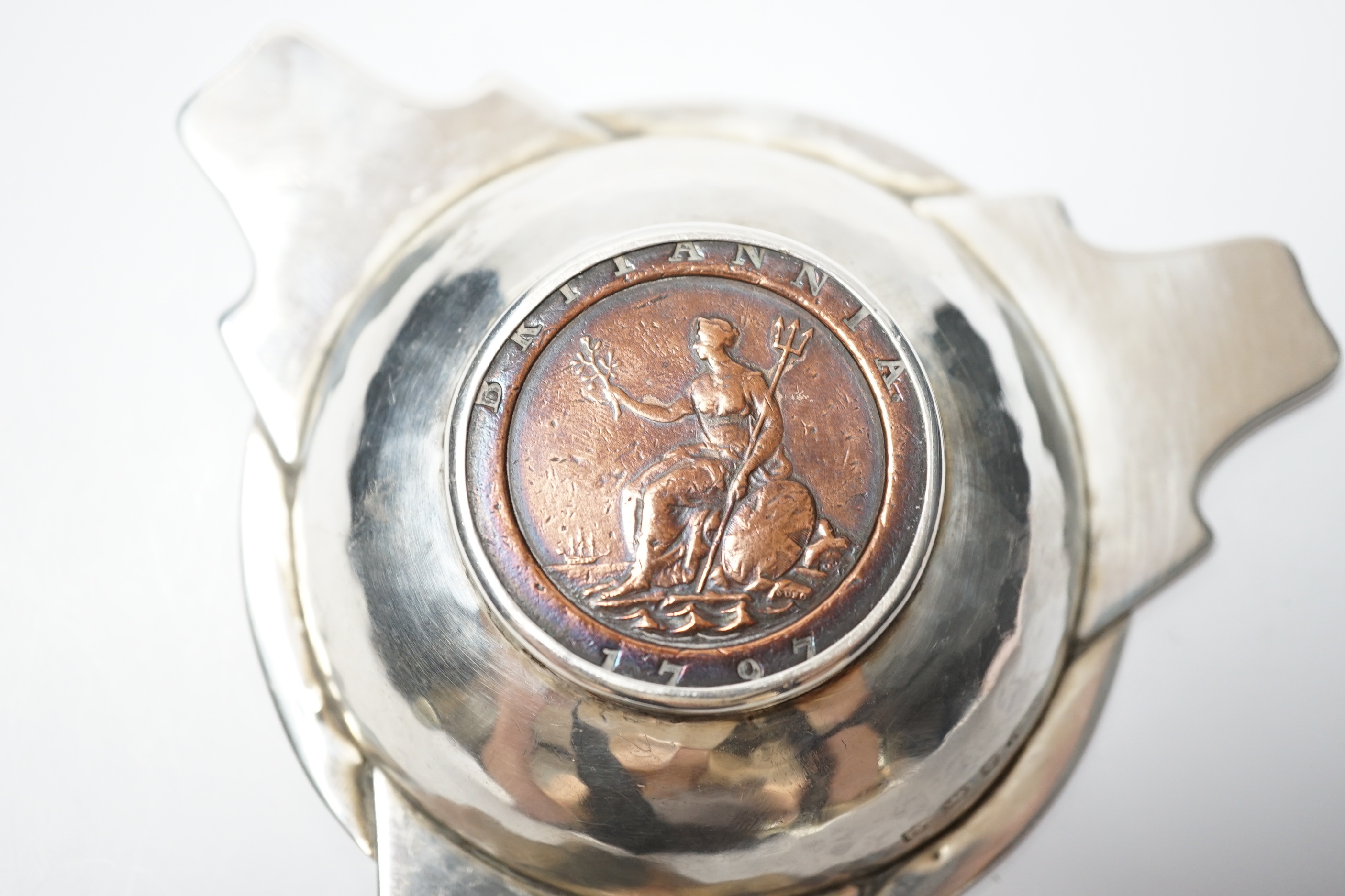 A George V Arts & Craft silver tri-form dish, by Albert Edwards Jones, Birmingham, 1913, the base with inset George III 1797 cartwheel penny, 10.8cm.